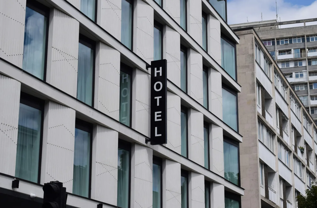 Modern hotel building facade with rows of reflective windows and signage