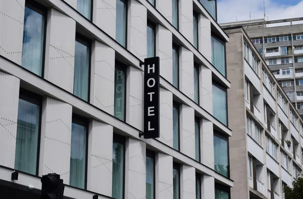 Modern hotel building facade with rows of reflective windows and signage