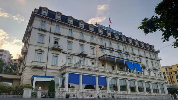 Historic multi-story hotel building with elegant mansard roof and ornate balconies