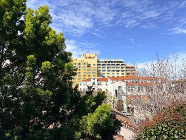 Modern hotel building with white residential structure and bare trees