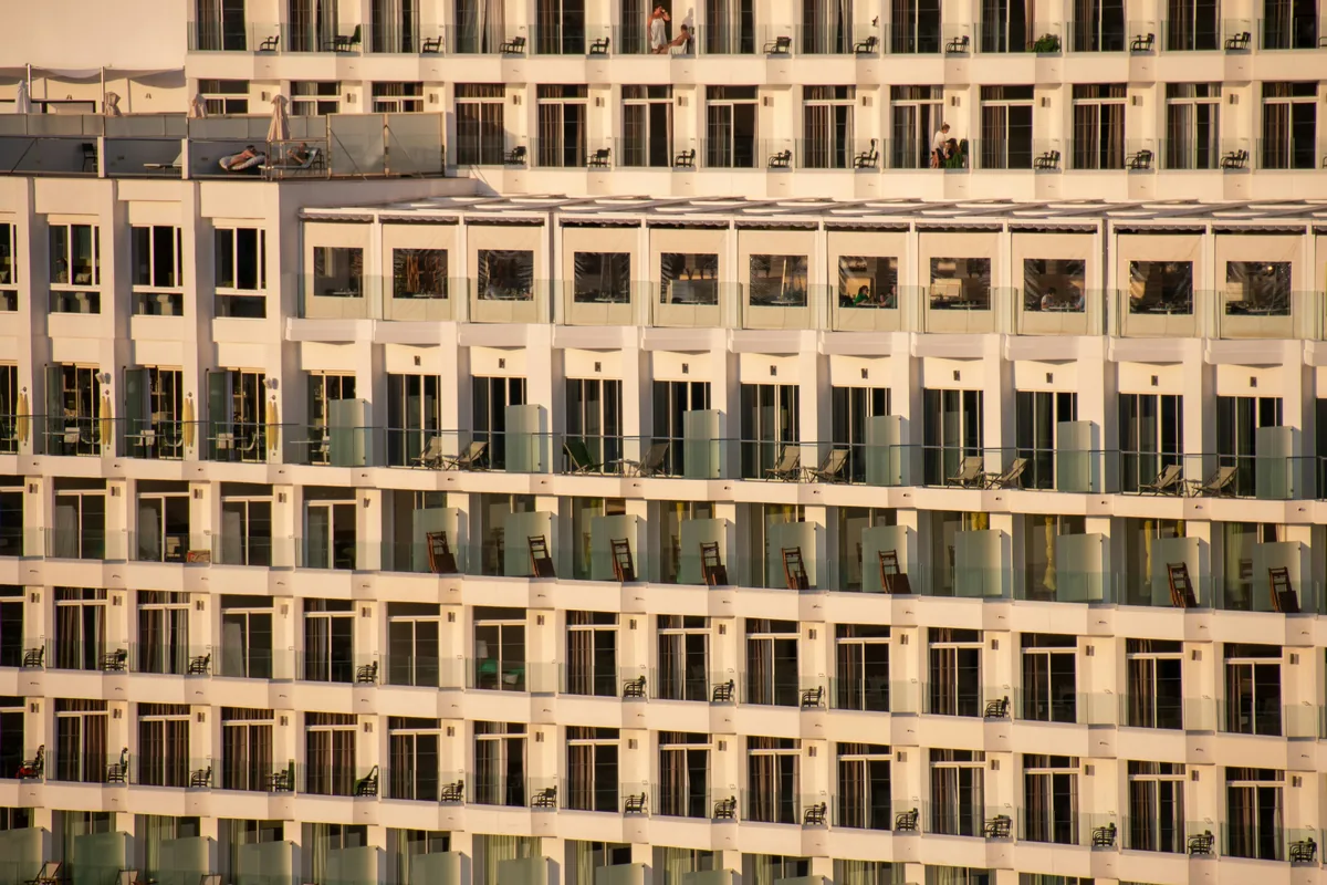 Modern multi-story office building facade with repetitive windows and balconies