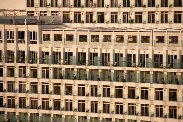 Modern multi-story office building facade with repetitive windows and balconies