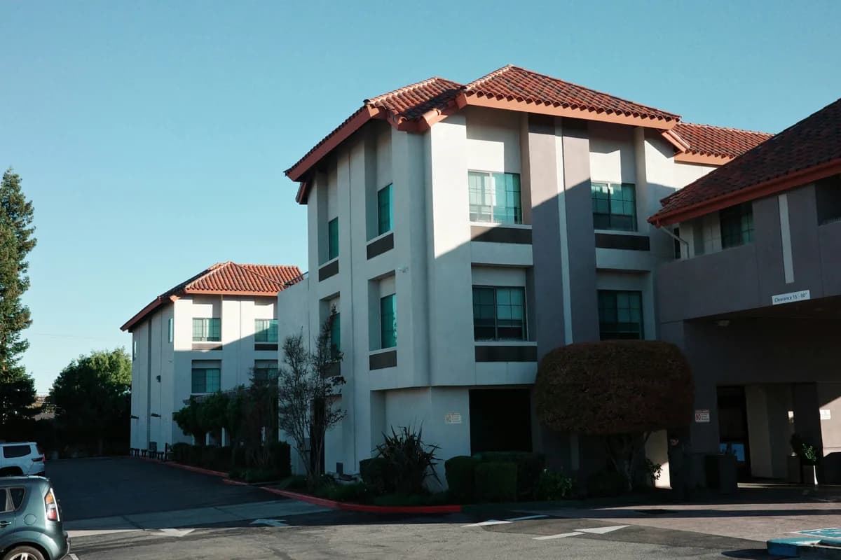 Modern white residential building with terracotta tile roofs and large windows