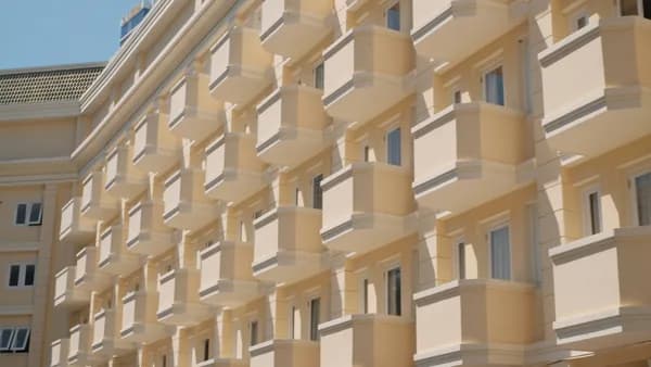 Modern residential building facade with numerous windows and curved balconies