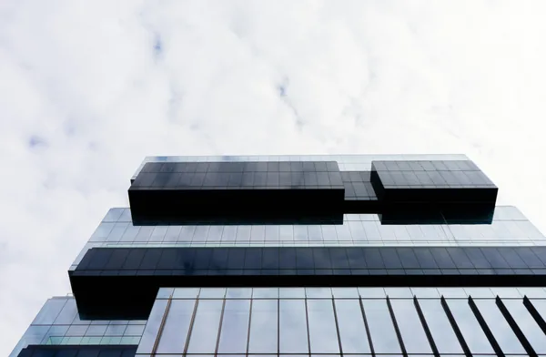Modern glass and metal building exterior with reflective windows and architectural design