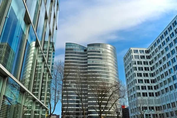 Modern glass office buildings with reflective windows and clear sky