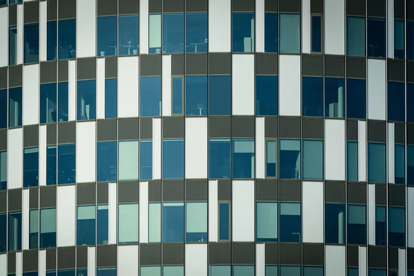 Modern building facade with repetitive pattern of windows and metal panels