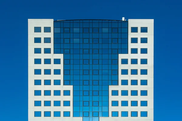 Modern office building facade with blue glass and white panel exterior walls