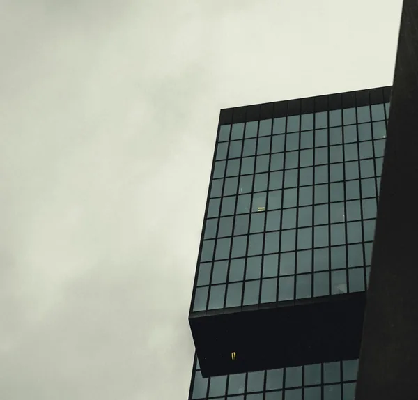 Modern office building facade with gridded windows against overcast sky