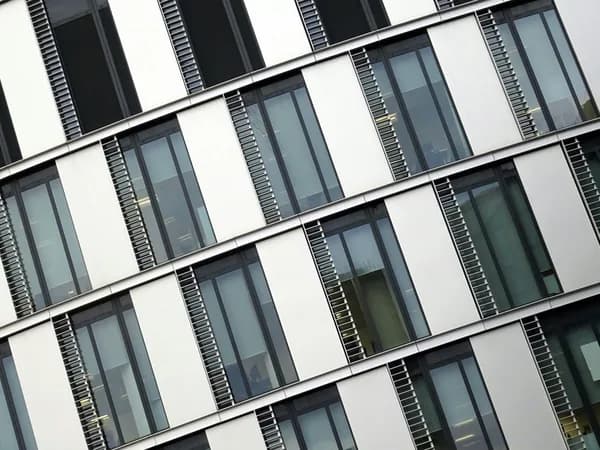 Modern building facade with alternating white panels and multi-pane windows