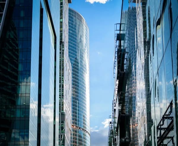 Tall modern skyscrapers with reflective glass facades and clear blue sky
