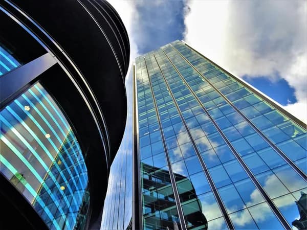 Tall modern skyscraper with reflective glass facade and blue sky
