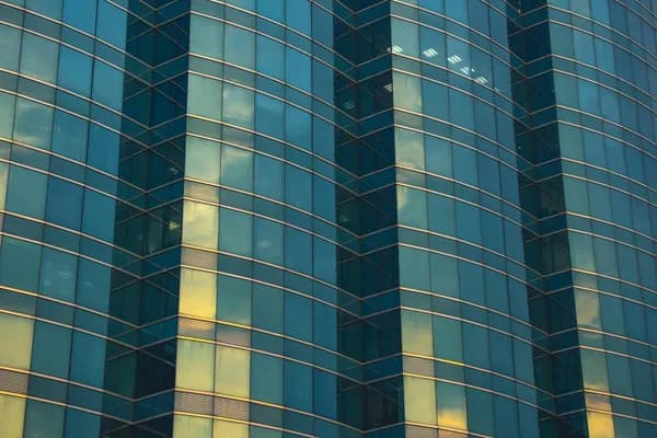Modern skyscraper exterior with clean glass windows and geometric grid pattern