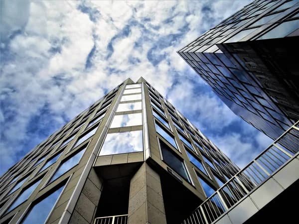 Modern high-rise building exterior with reflective glass windows and metal framework