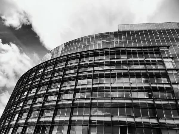 Modern curved glass building facade with geometric window grid pattern