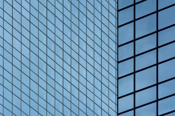 Modern glass building facade with reflective windows and metal framing grid