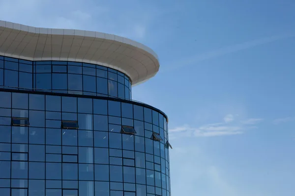 Modern curved glass building facade with geometric window grid pattern