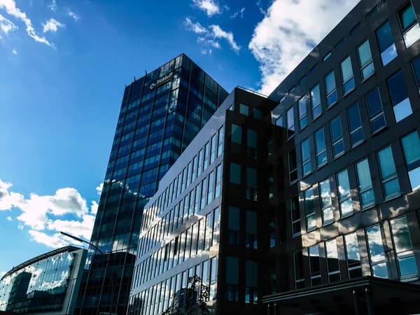 Modern office buildings with reflective glass windows under blue sky