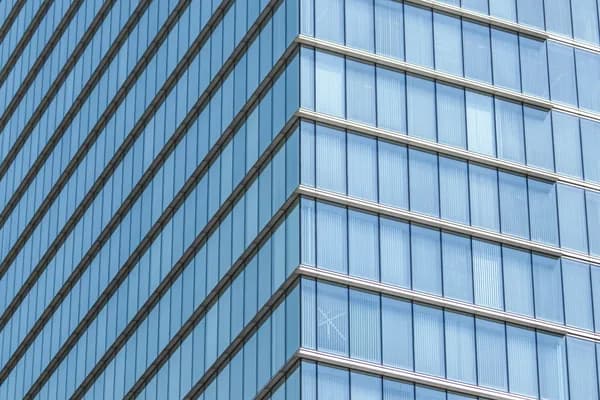 Modern glass skyscraper exterior with reflective windows and metal framework