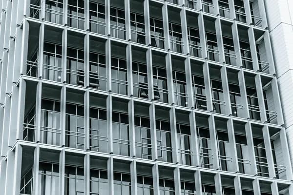 Modern commercial building facade with rows of large windows and balconies