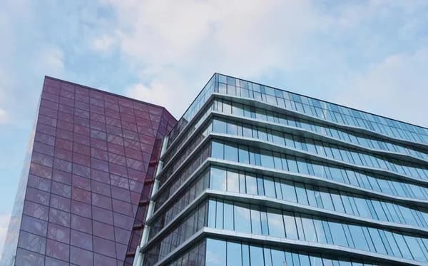Modern multi-story office buildings with extensive glass facades and windows