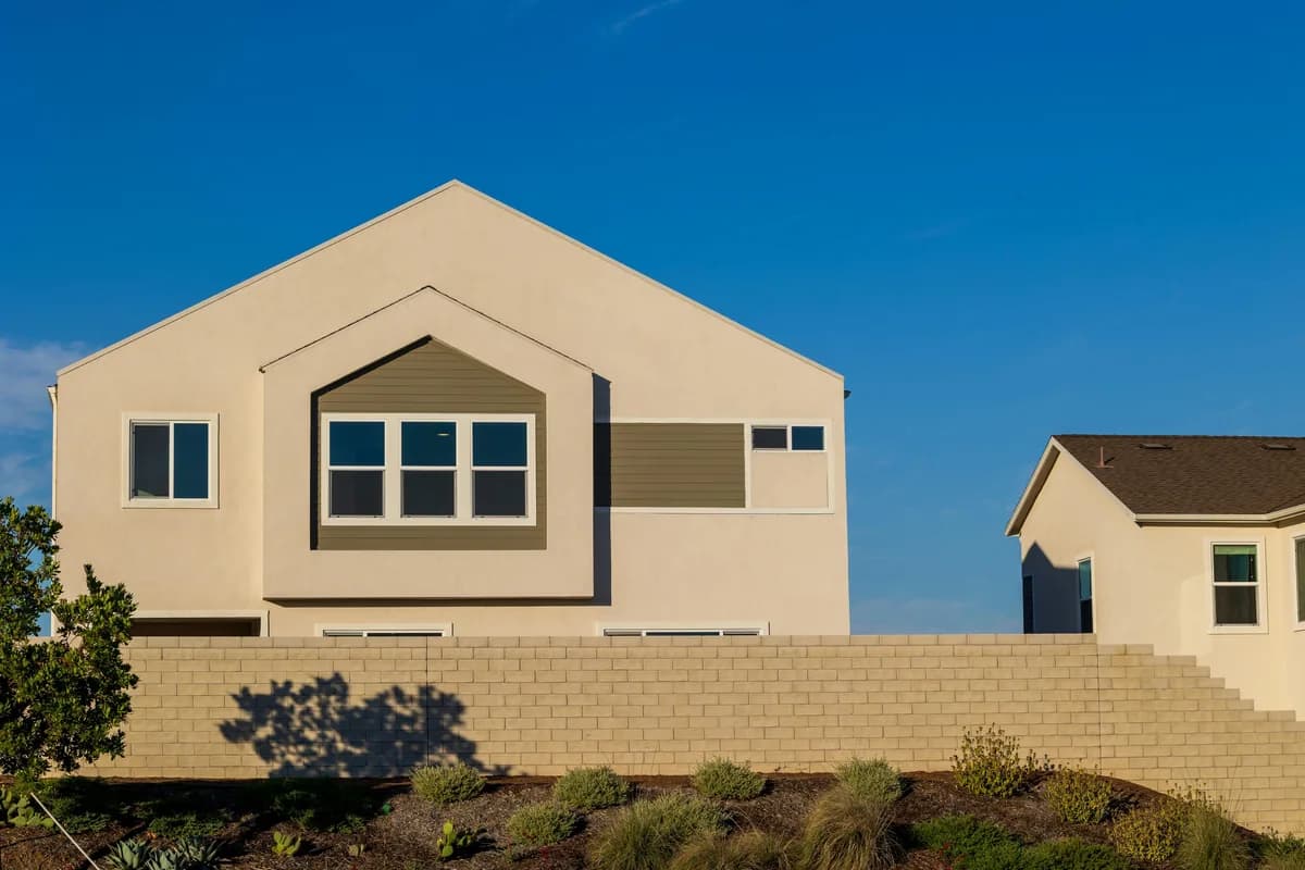 Modern residential house with large windows and cream-colored exterior walls