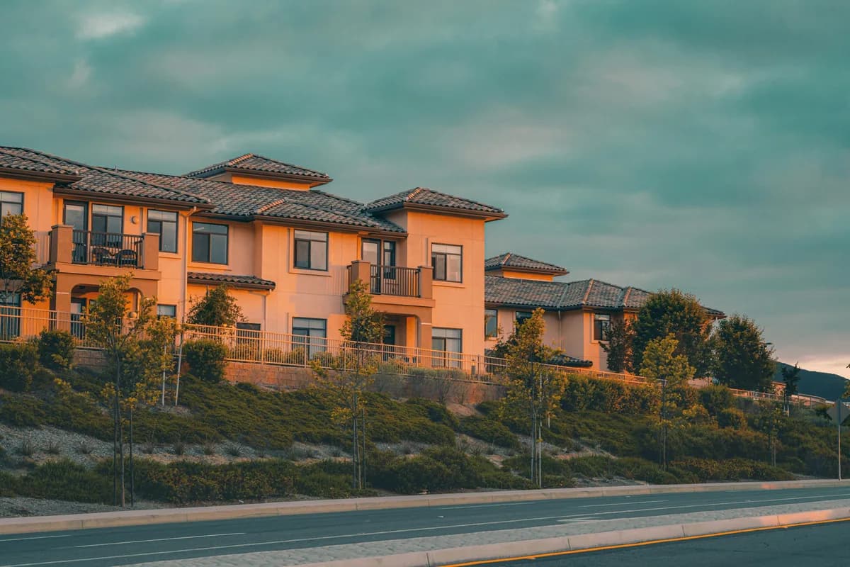 Modern orange residential building with multiple windows and balconies on hillside
