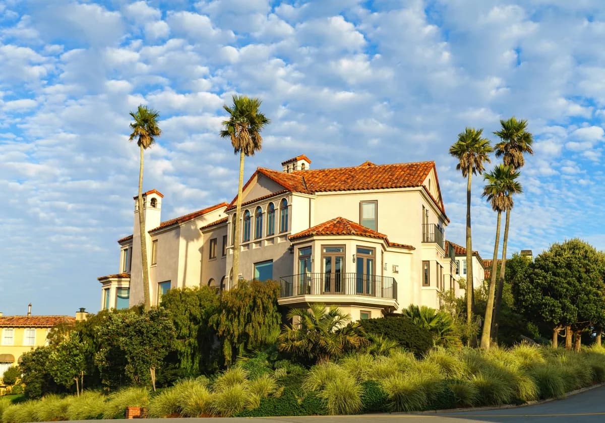Spanish colonial style mansion with cream stucco exterior and terracotta tile roof