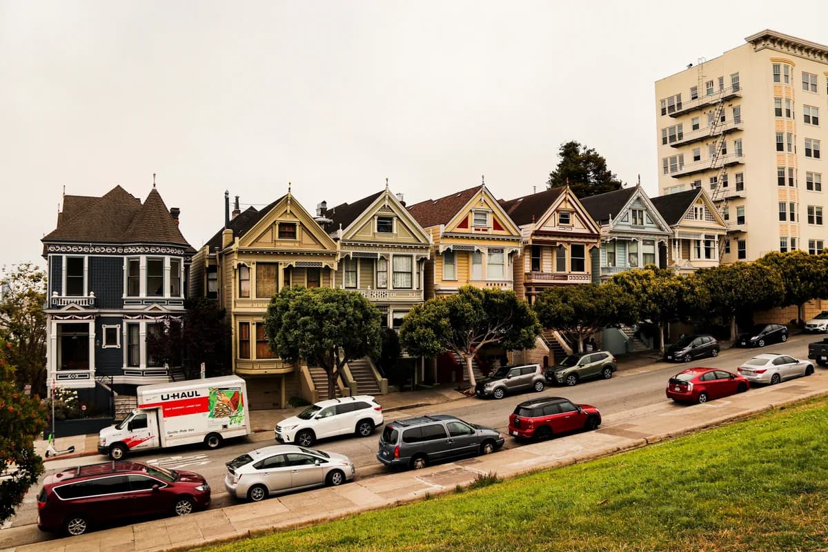 Row of Victorian houses with modern apartment building and parked cars