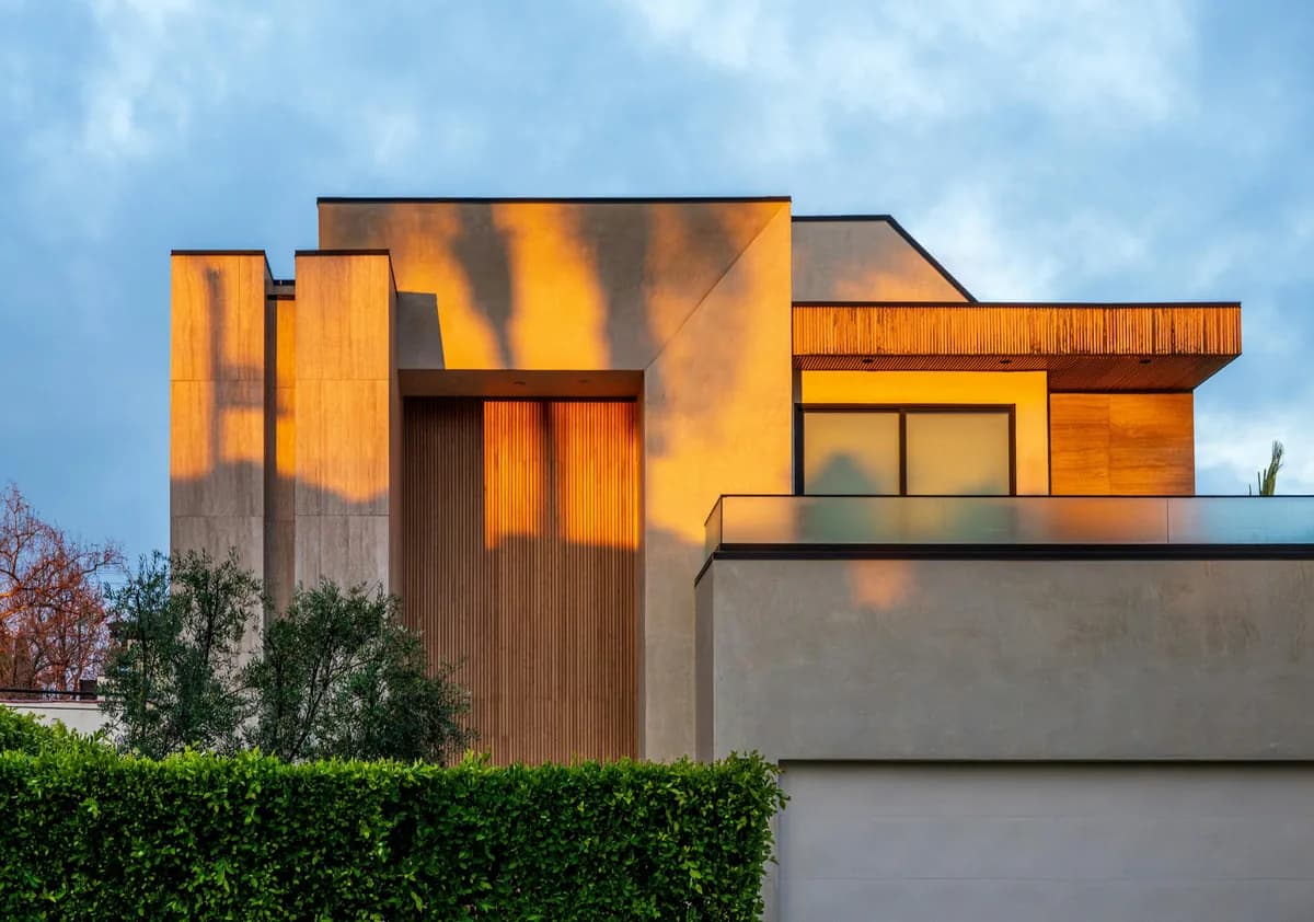 Modern residential building with reflective glass surfaces and corrugated metal cladding