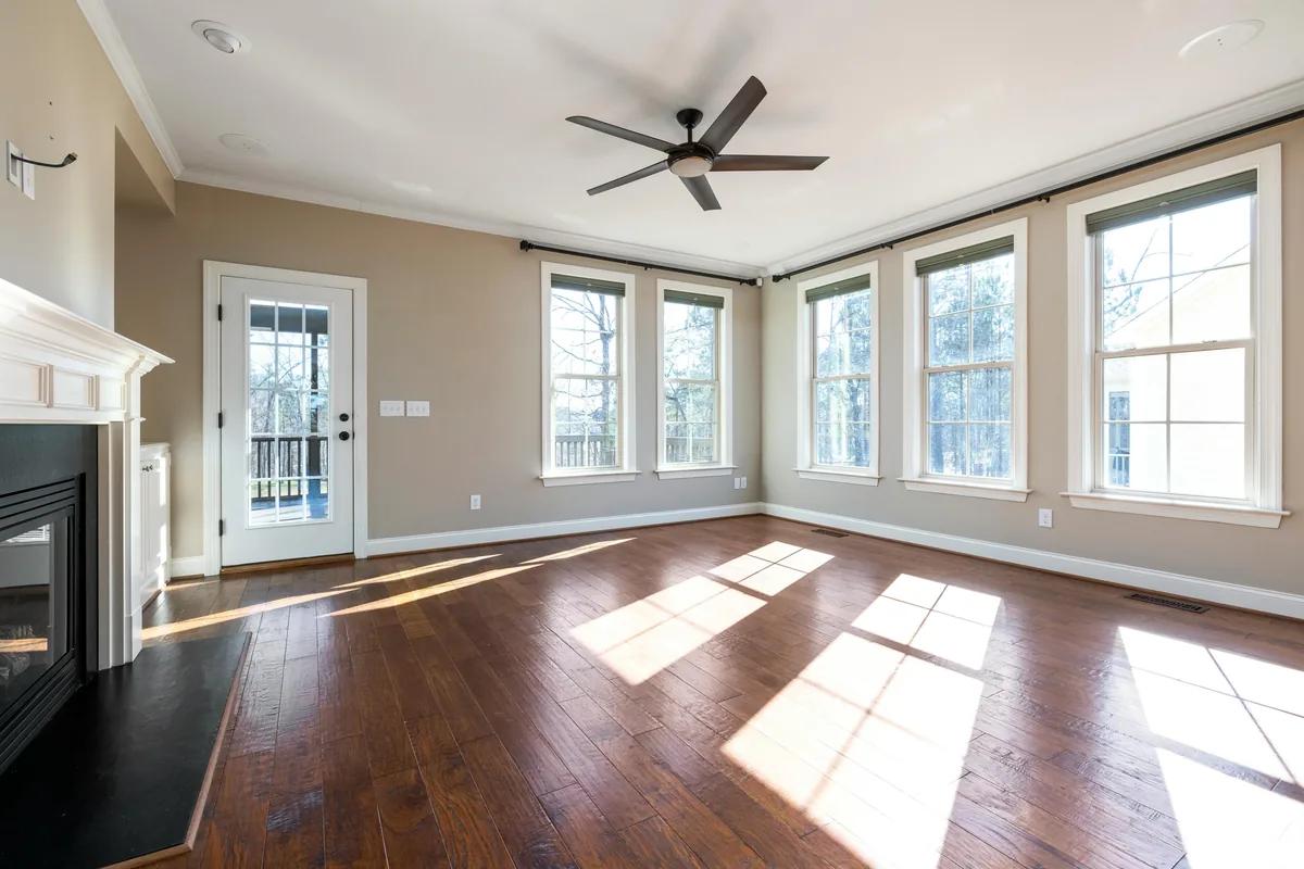 Bright sunlit room with multiple large windows and glass doors