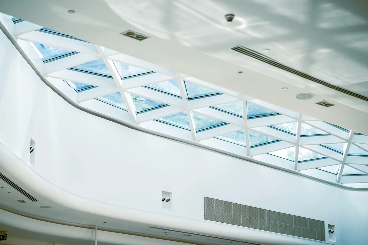 Modern ceiling with skylights and geometric glass panels in bright interior space