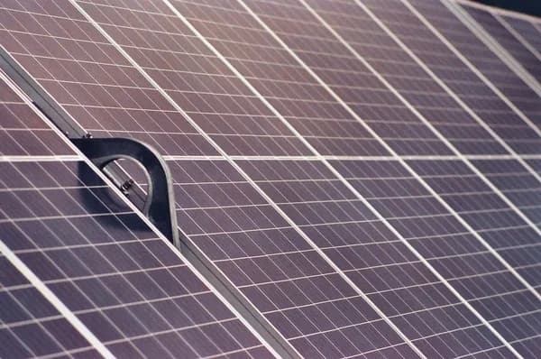 Metal mounting bracket installed on solar panel array in sunlight