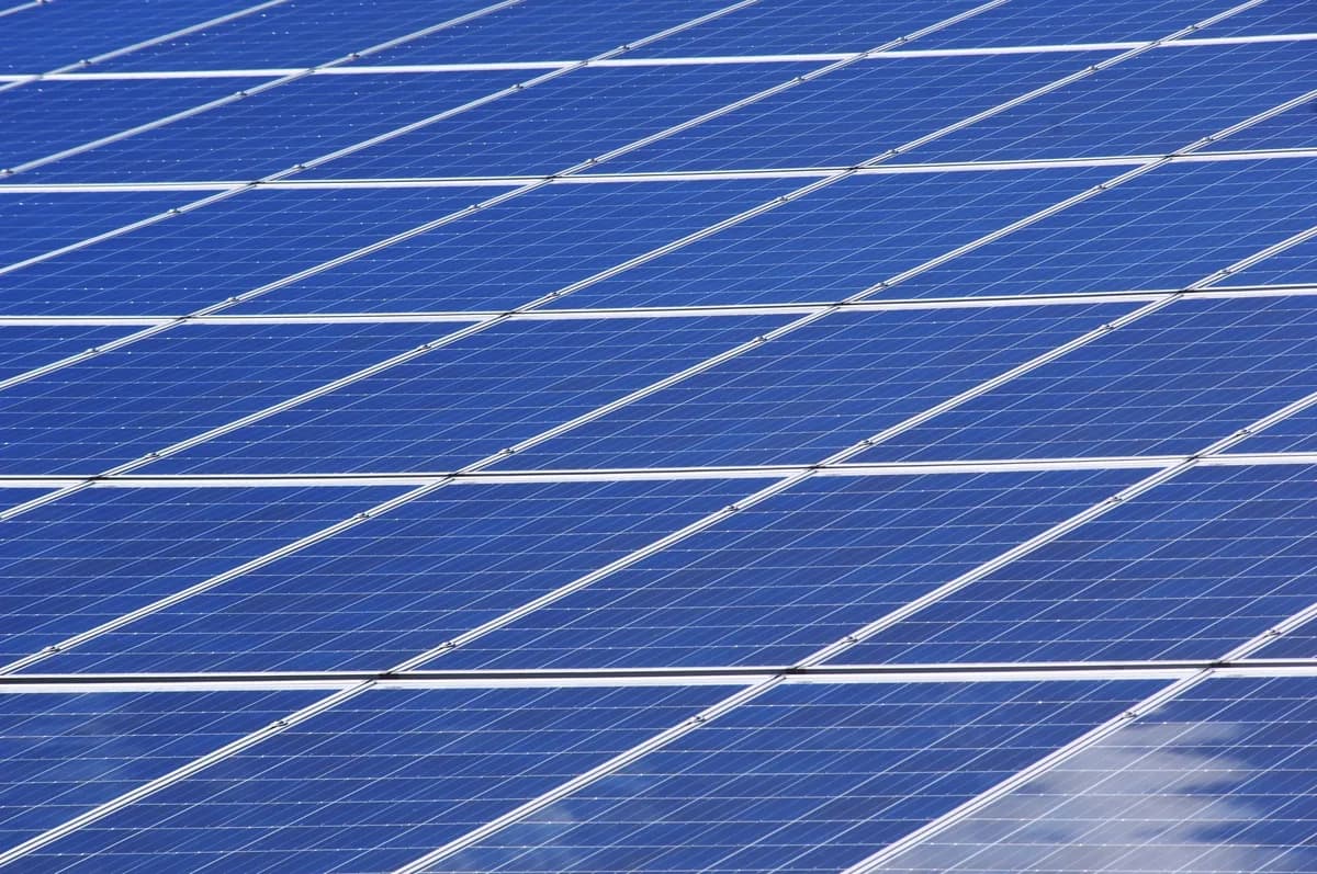 rows of blue solar panels with white frames and connecting lines