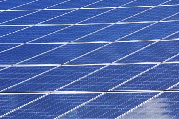 rows of blue solar panels with white frames and connecting lines
