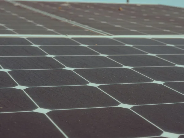 Close-up view of solar panel cells with light blue grid lines separating dark surfaces