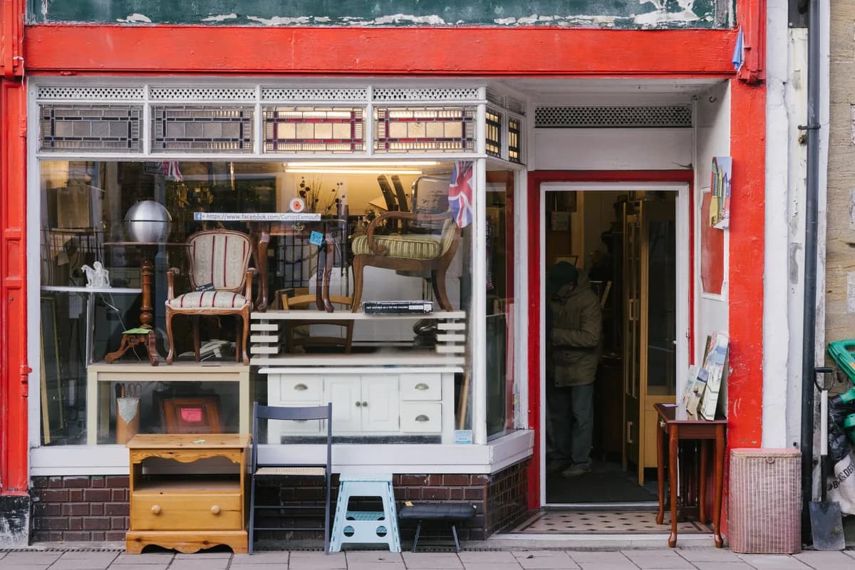 Antique furniture shop storefront with red painted facade and decorative items displayed