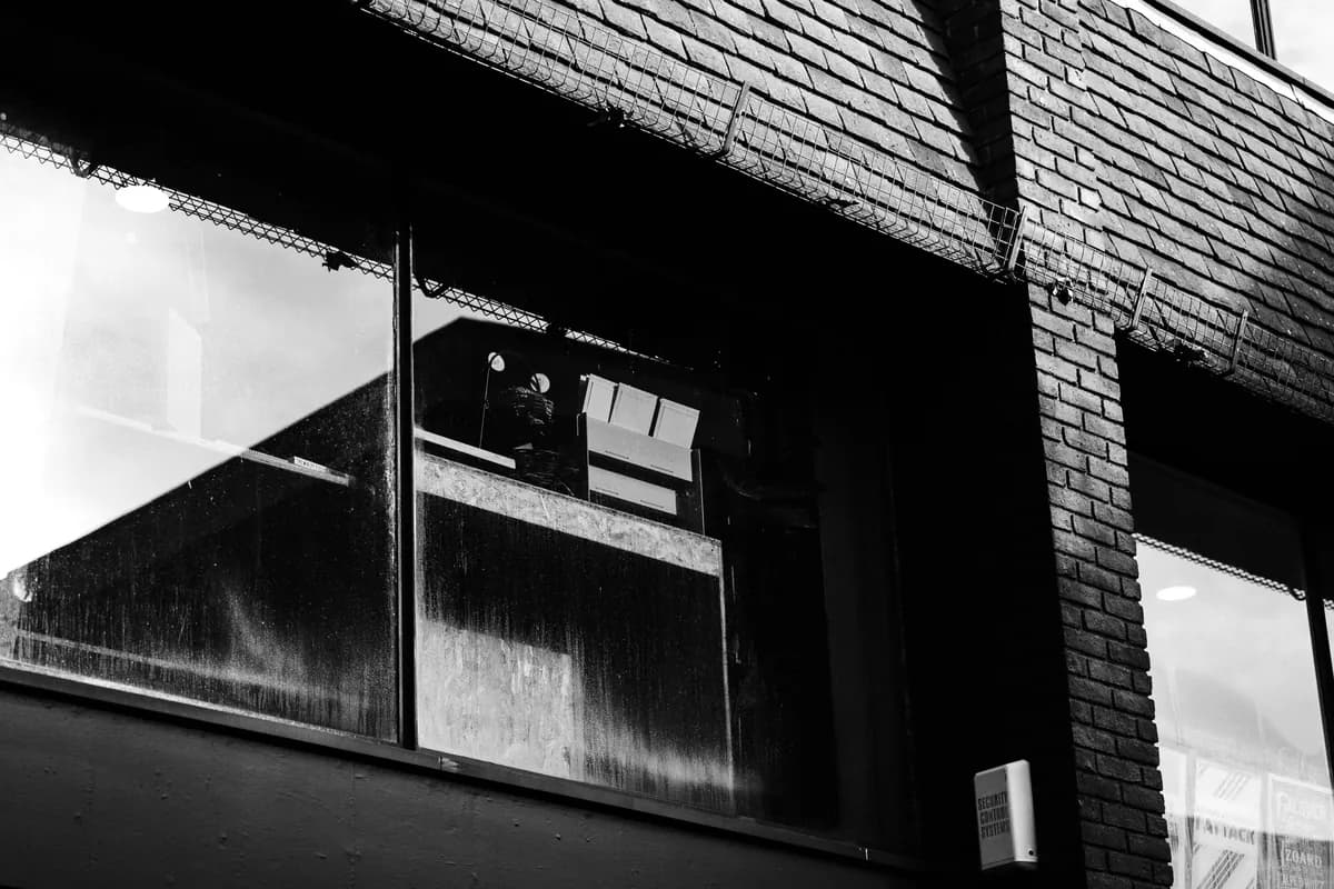 Dark industrial building exterior with windows and metal framework structure