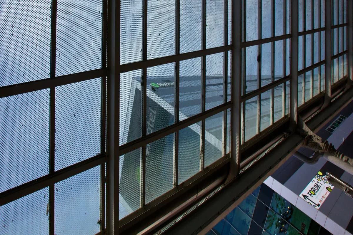 Dark-framed windows with gridded panes overlooking urban building exterior