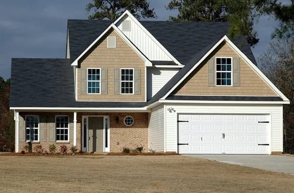 Two-story residential house with multiple windows and brick facade exterior