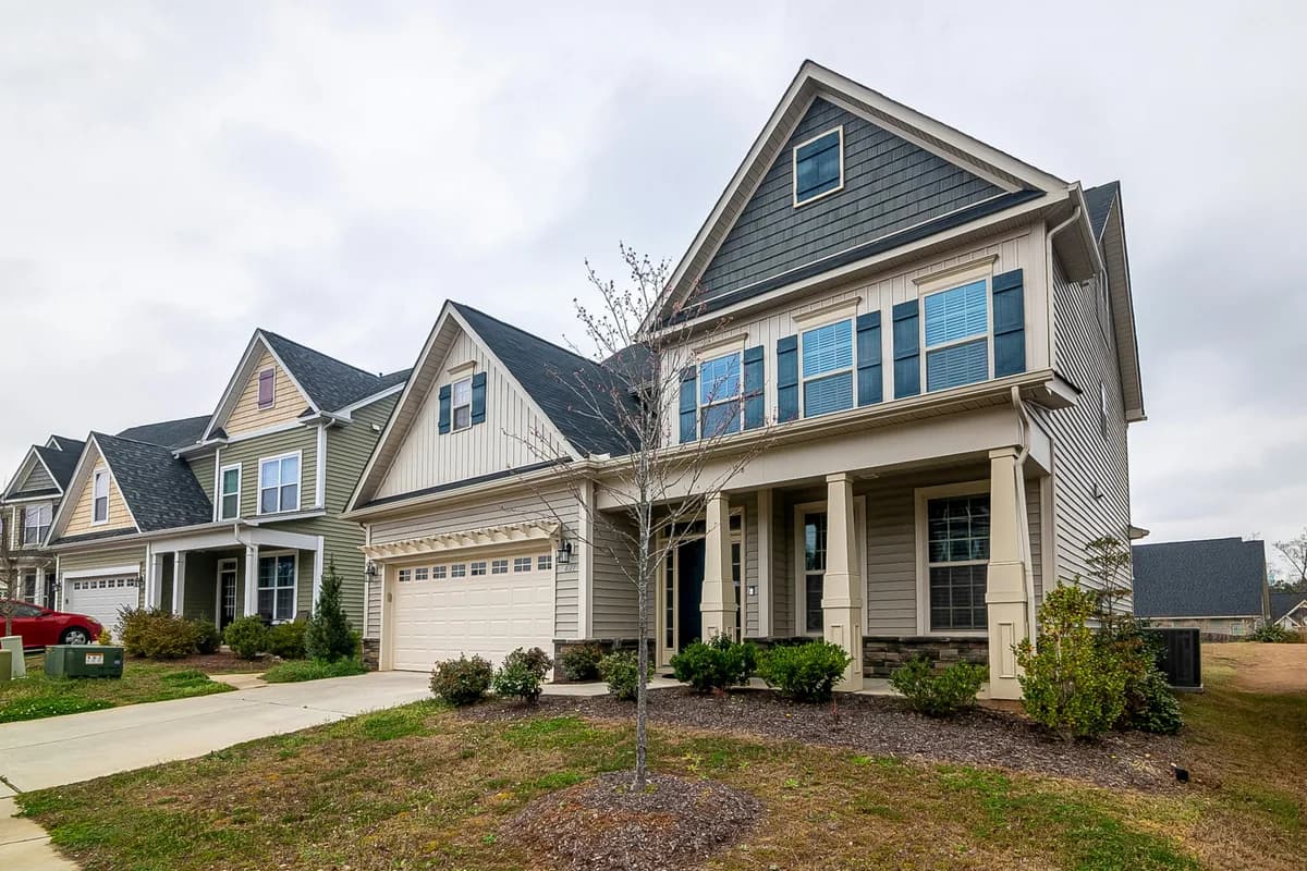 Two-story residential home with large windows and light-colored siding