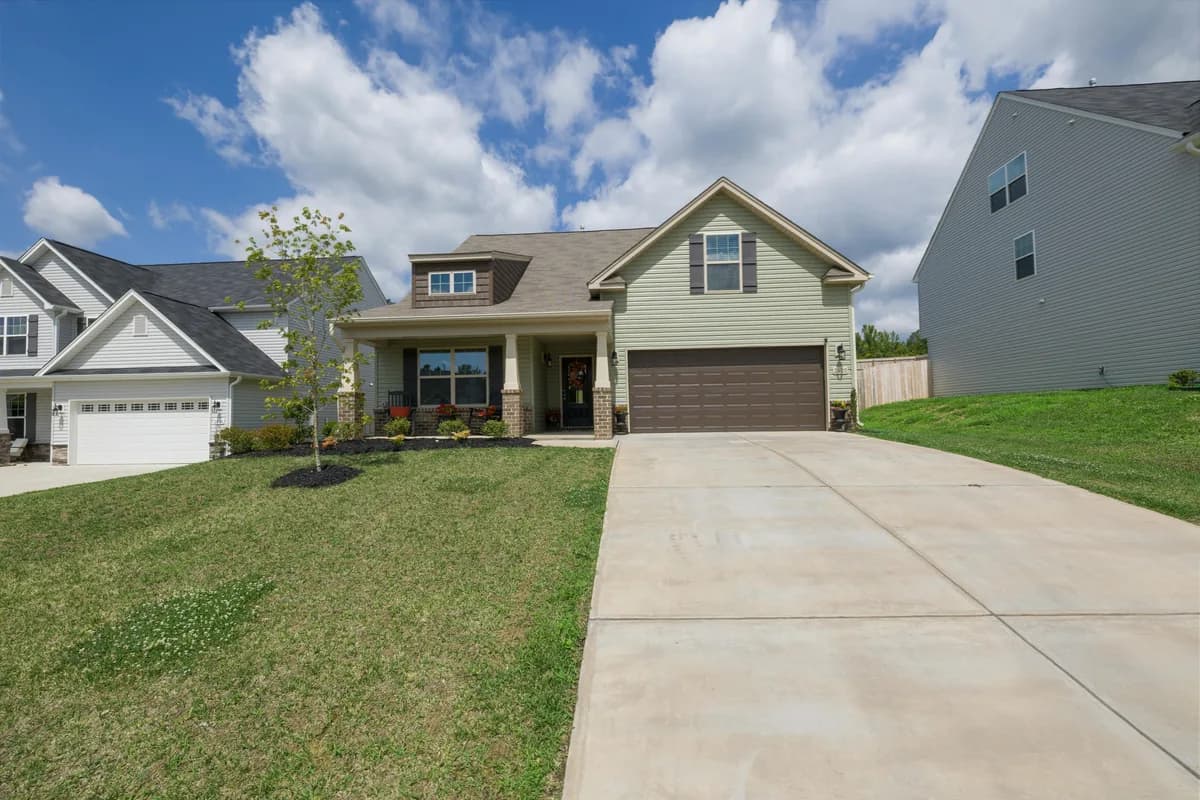 Two-story residential home with brick foundation and manicured lawn