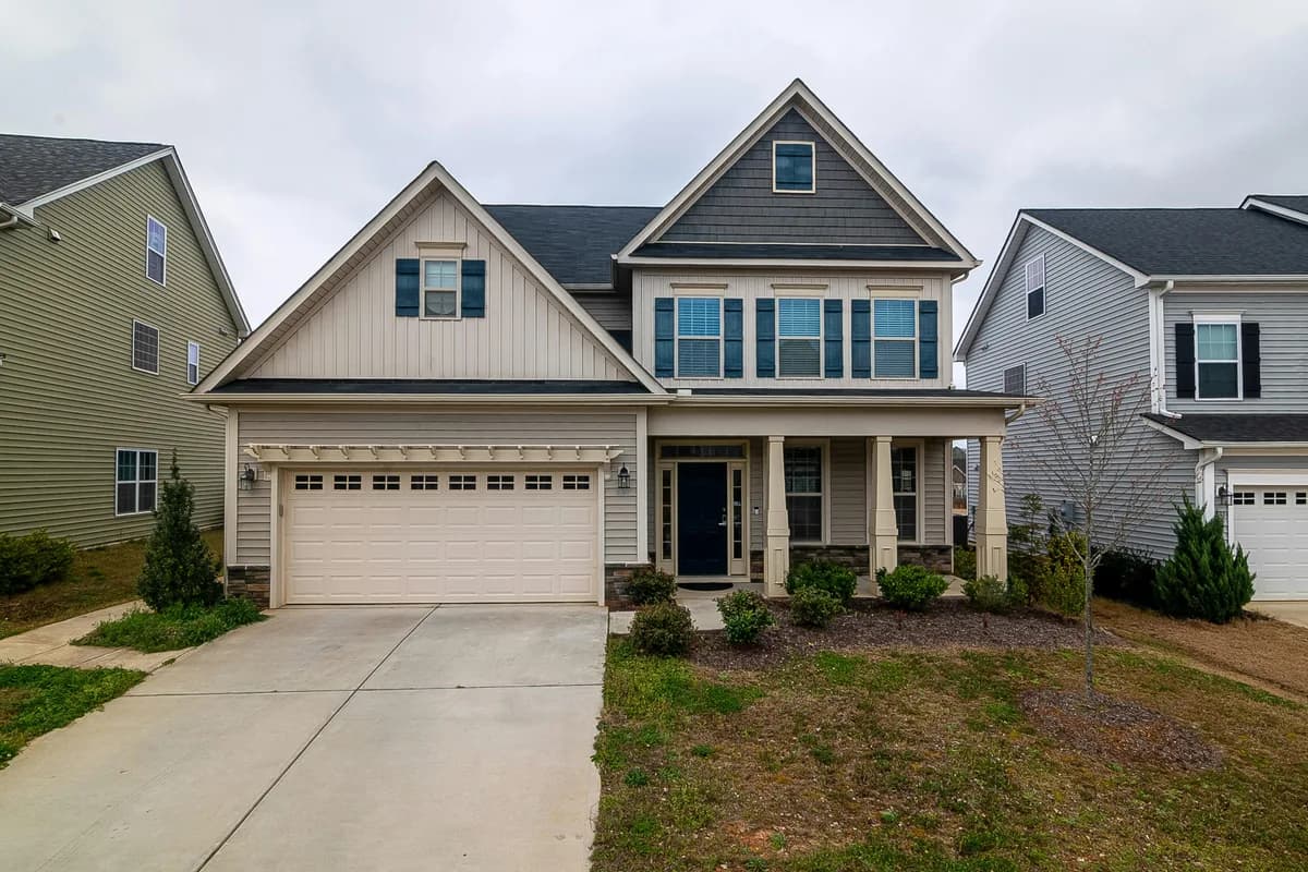 Two-story residential home with multiple windows and front porch