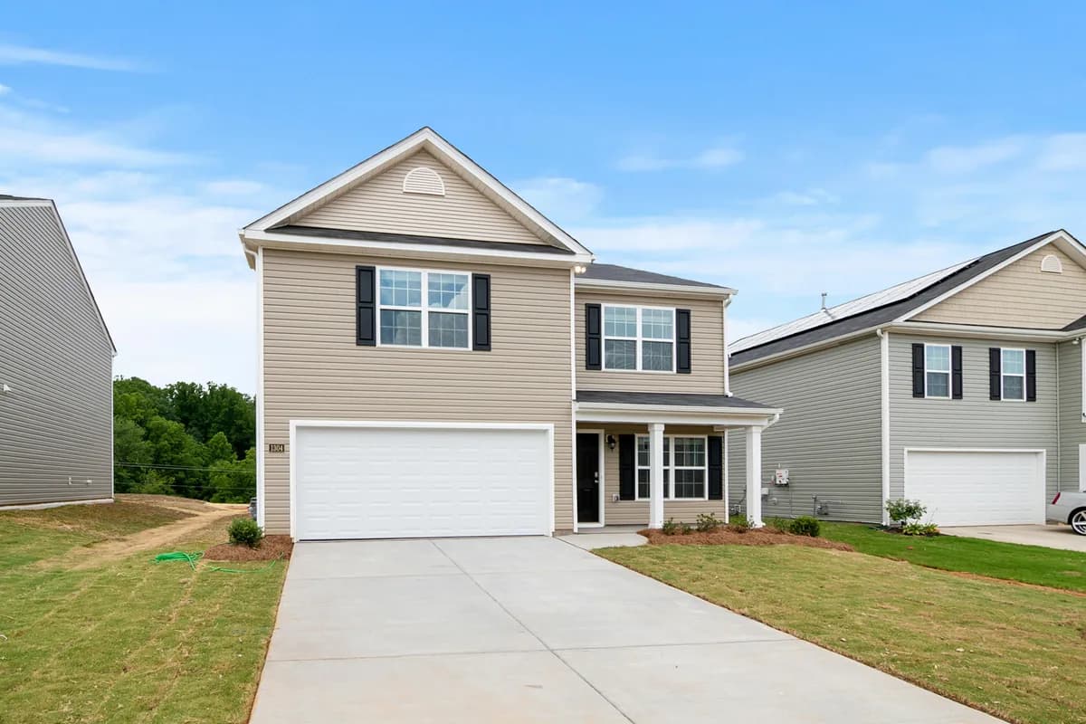 Two-story residential house with white garage door and black shutters