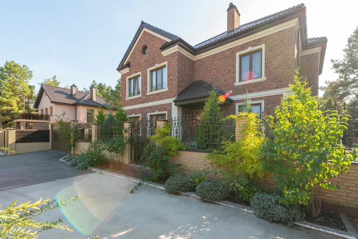 brick residential house exterior with large windows and landscaped garden entrance