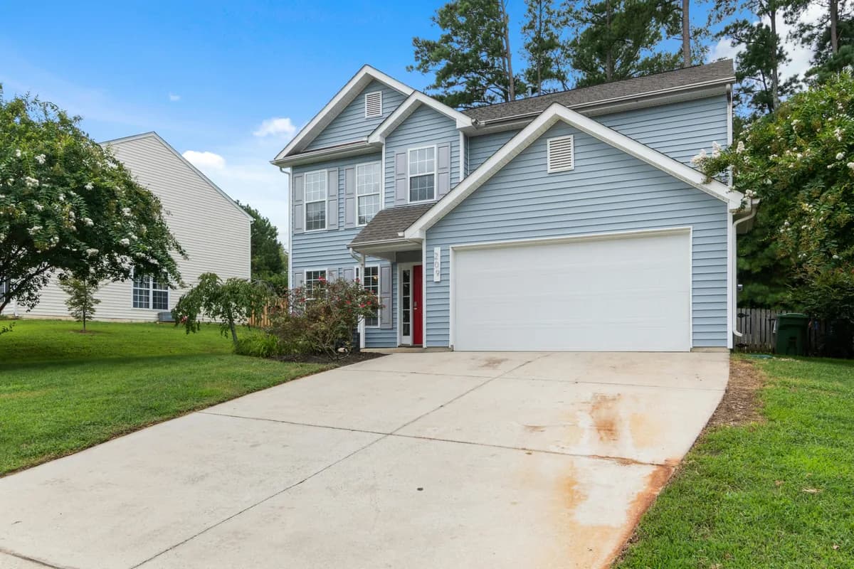 Two-story residential house with blue siding and white garage door