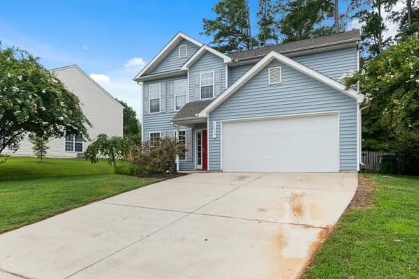Two-story residential house with blue siding and white garage door