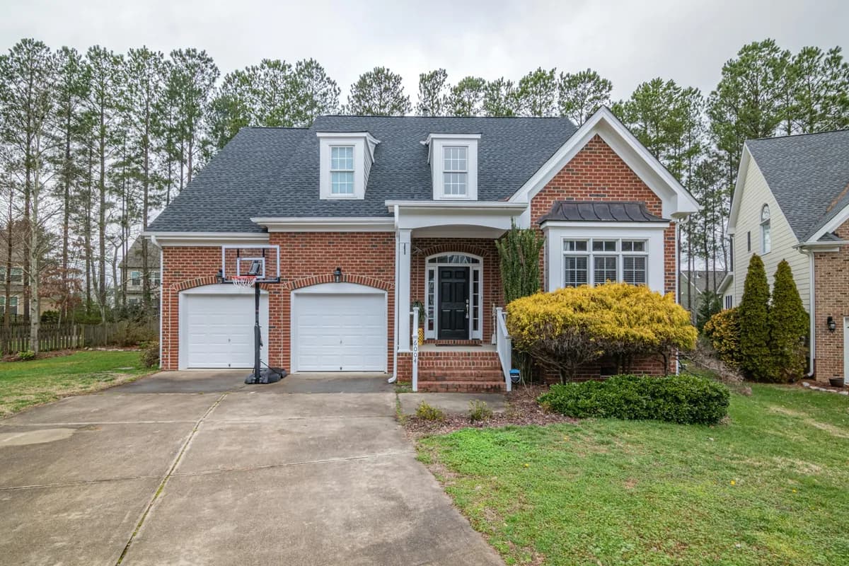 Brick residential home with white trim and multiple windows and dormers
