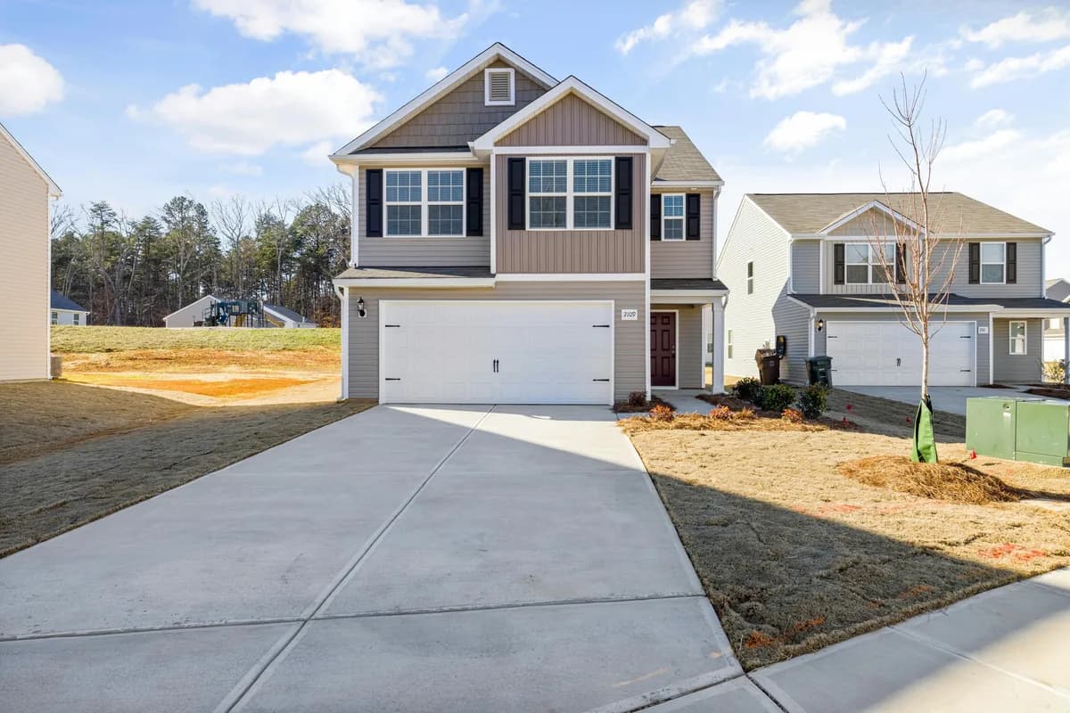 Two-story residential home with garage and minimal landscaping under construction