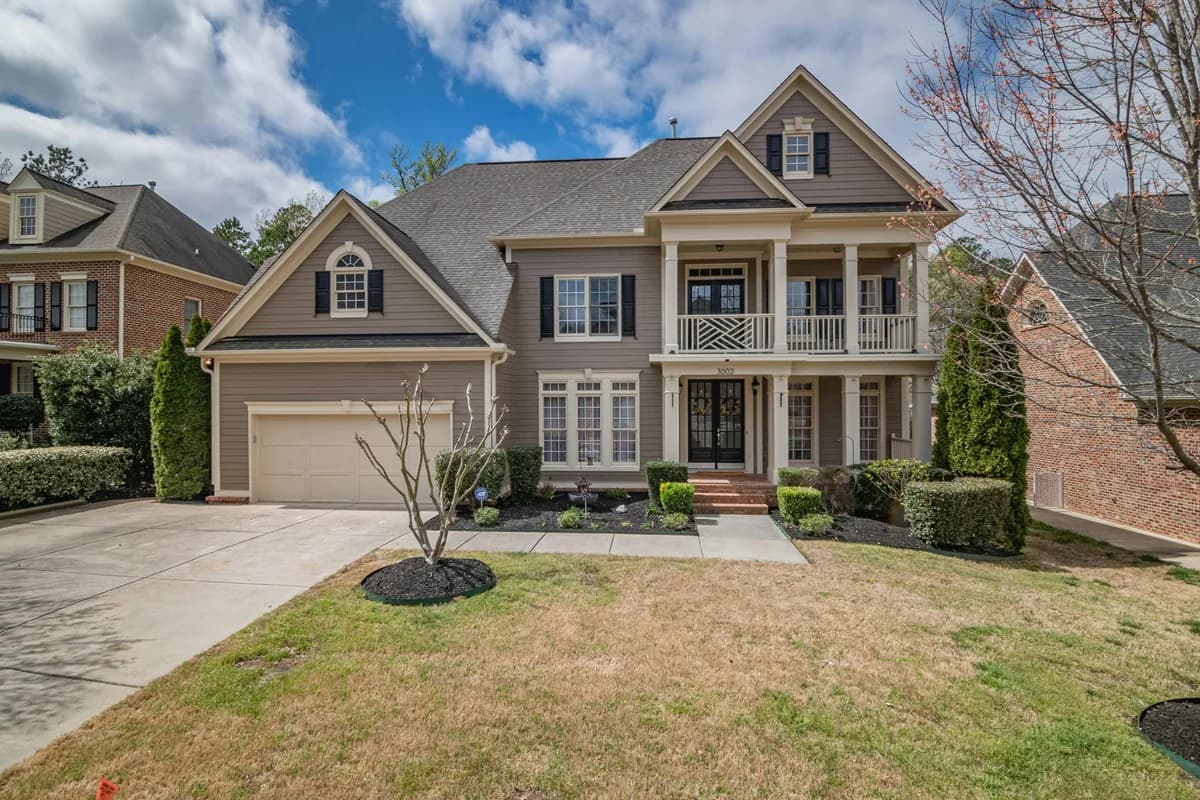 Two-story residential home with large windows and brick exterior facade